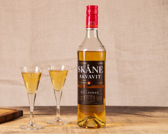 Flaskan av Skåne Akvavit Fatlagrad och två glas med snaps.